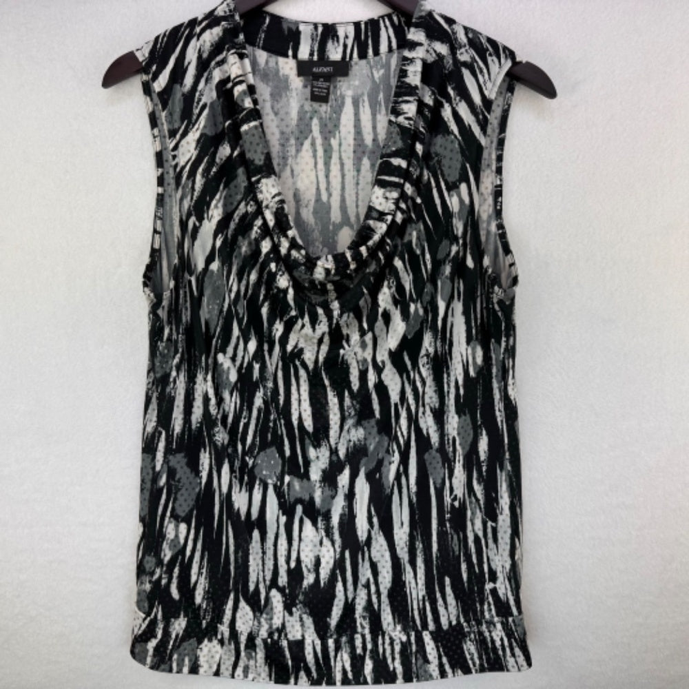 A sleeveless V-neck top with a black, gray, and white abstract pattern, hanging on a dark hanger against a light textured wall.