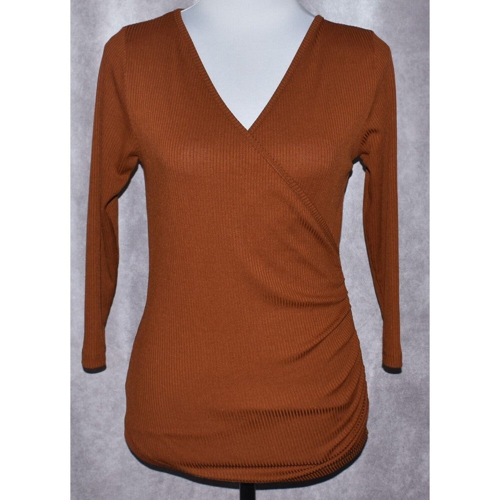A rust-brown ribbed long-sleeve wrap-style top displayed on a white mannequin torso against a textured gray background.