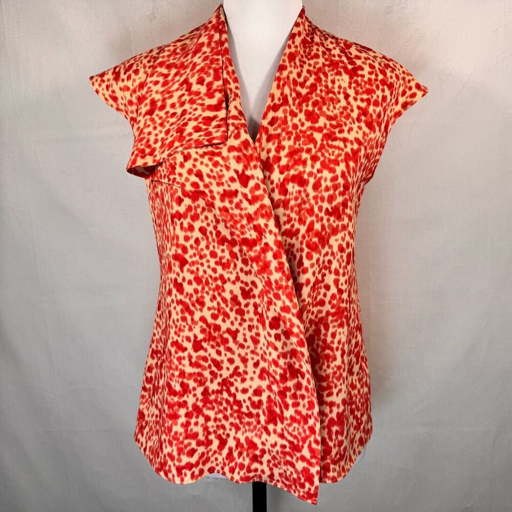 A red and beige leopard print wrap-style blouse displayed on a white mannequin torso against a light gray fabric backdrop.