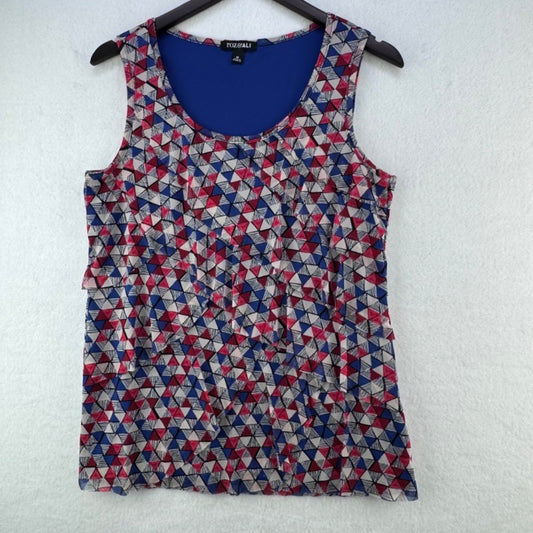 A sleeveless scoop-neck top with a geometric triangle pattern in navy blue, red, and beige, hanging on a black hanger against a white textured wall. The brand name 'FASHION' is visible on the inner neck label.