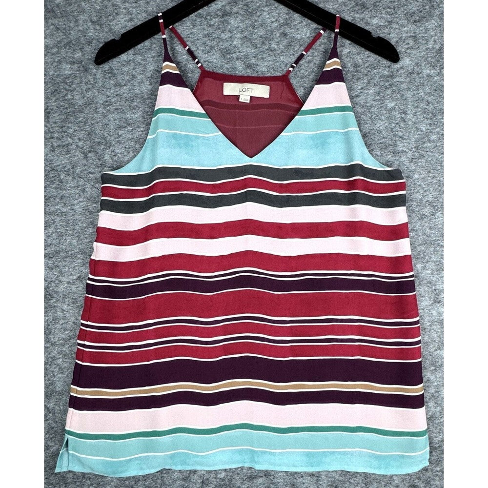 A striped camisole tank top with thin straps, hanging on a black hanger against a textured gray background. The top features horizontal stripes in red, light blue, white, dark gray, and deep purple.