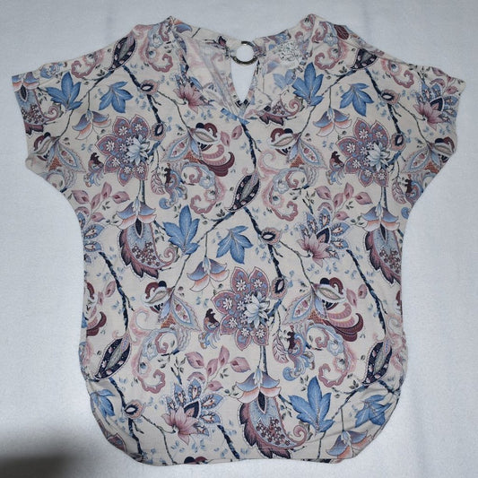 A short-sleeve blouse with a V-neckline, featuring an intricate floral and paisley pattern in shades of blue, pink, and brown on a light beige background.