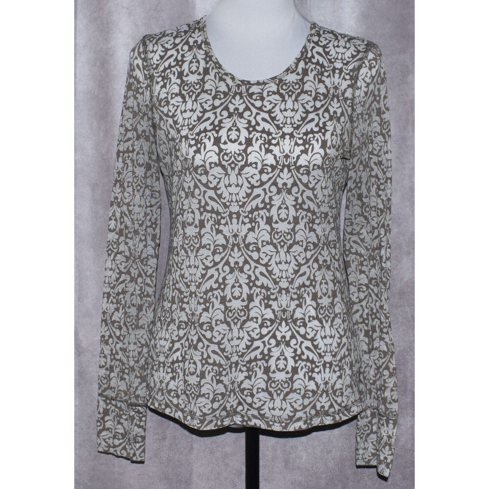 A long-sleeve scoop-neck blouse with an all-over damask pattern in brown and off-white, displayed on a mannequin torso against a textured gray backdrop.