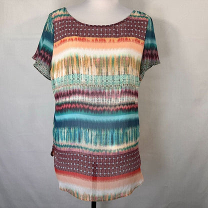 A short-sleeve tunic top with a colorful horizontal striped pattern, displayed on a mannequin torso against a light gray fabric backdrop.