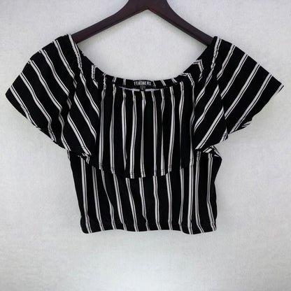 A black and white vertically striped short-sleeve crop top with a square neckline, hanging on a dark wooden hanger against a white textured background.