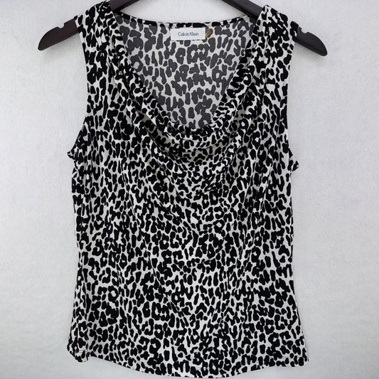 A Calvin Klein sleeveless top with a black and white leopard print pattern, hanging on a black hanger against a light gray textured background.