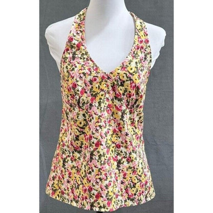 A sleeveless halter-style tank top with a dense multicolor floral print, displayed on a white mannequin torso against a dark gray background.