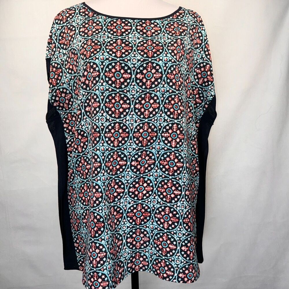 A women's short-sleeve top with a black base and a colorful geometric medallion pattern in turquoise, coral, and white. The sleeves are solid black.