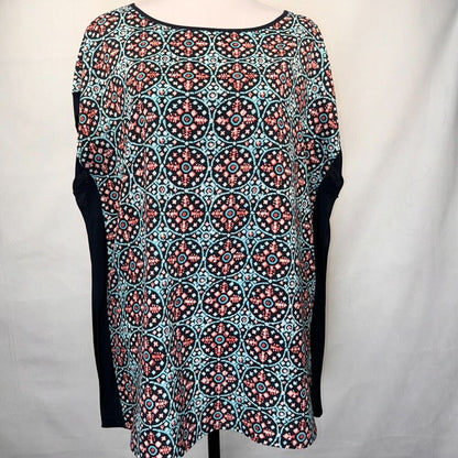 A women's short-sleeve top with a black base and a colorful geometric medallion pattern in turquoise, coral, and white. The sleeves are solid black.