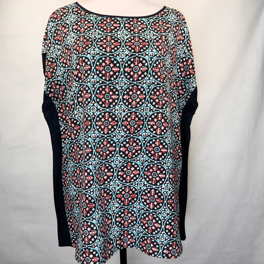 A women's short-sleeve top with a black base and a colorful geometric medallion pattern in turquoise, coral, and white. The sleeves are solid black.