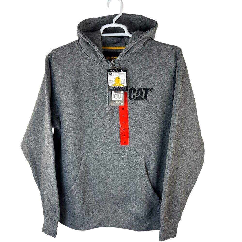 A gray heathered CAT brand pullover hoodie hanging on a white hanger against a white background, featuring a black CAT logo on the left chest and a red-and-white hangtag attached to the neck.