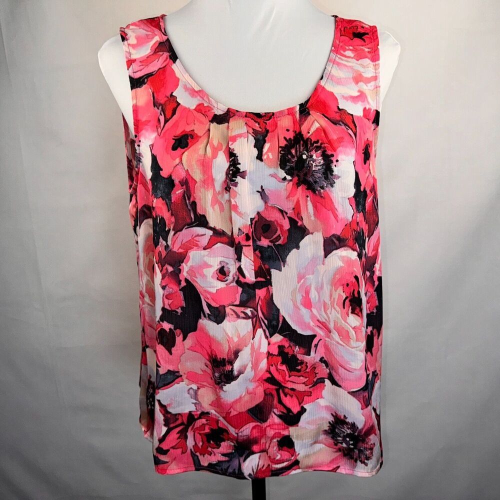 A sleeveless scoop-neck blouse with a vibrant pink, red, and white floral print on a black background, displayed on a white mannequin torso against a light gray fabric backdrop.