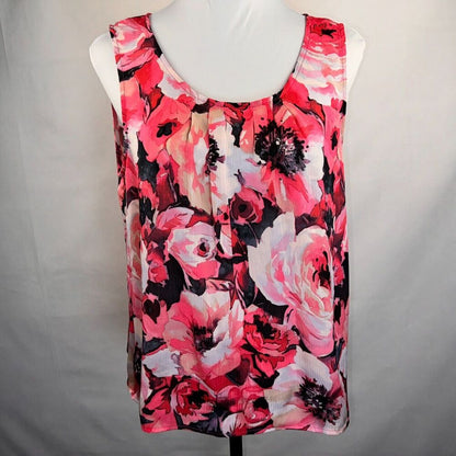 A sleeveless scoop-neck blouse with a vibrant pink, red, and white floral print on a black background, displayed on a white mannequin torso against a light gray fabric backdrop.