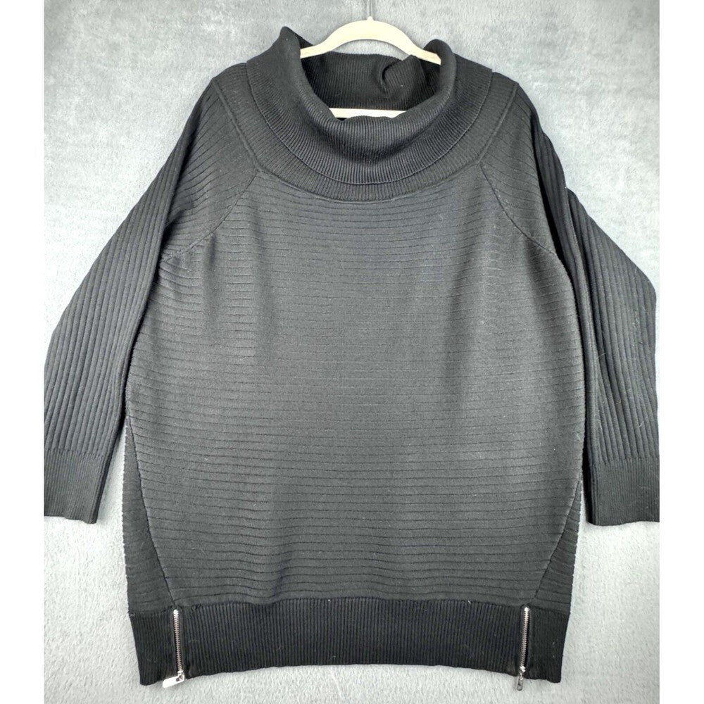 A dark gray ribbed knit sweater with a mock neck, raglan sleeves, and silver zipper details at the hem, hanging on a white hanger against a textured gray background.