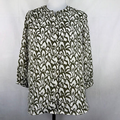 A women's long-sleeve blouse with a textured, raised abstract pattern in olive green and off-white, displayed on a mannequin torso against a light gray background.