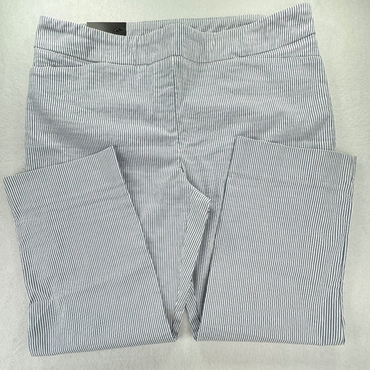 A pair of folded pants with a fine vertical stripe pattern in navy blue and white, laid flat on a light gray background.