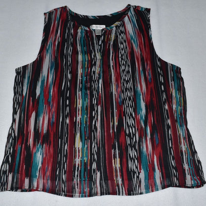 A sleeveless top with a vibrant vertical ikat-style stripe pattern in red, teal, black, white, and beige, laid flat on a light gray background.
