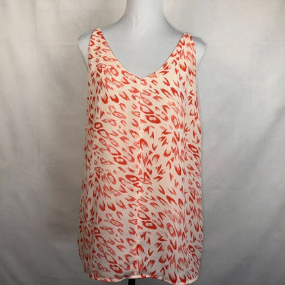 A sleeveless V-neck top with an abstract red and orange brushstroke pattern on a white base, displayed on a gray mannequin torso against a light gray fabric backdrop.