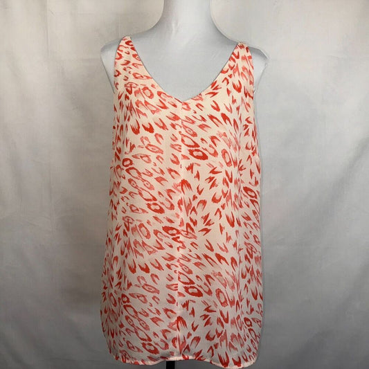 A sleeveless V-neck top with an abstract red and orange brushstroke pattern on a white base, displayed on a gray mannequin torso against a light gray fabric backdrop.