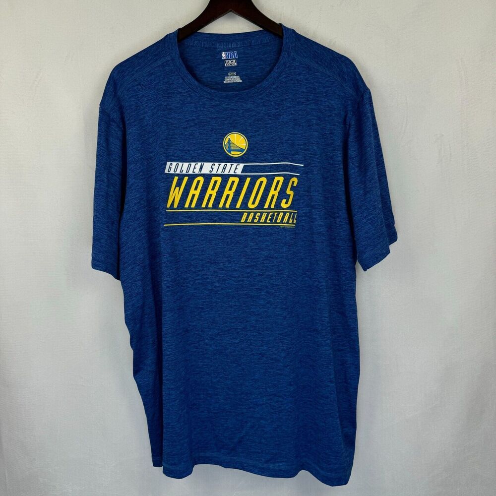 A blue heathered short-sleeve t-shirt hanging on a dark wooden hanger against a light gray textured wall. The front features a yellow and white graphic with the Golden State Warriors logo and the text 'LAKERSHIP WARRIORS BASKETBALL'.