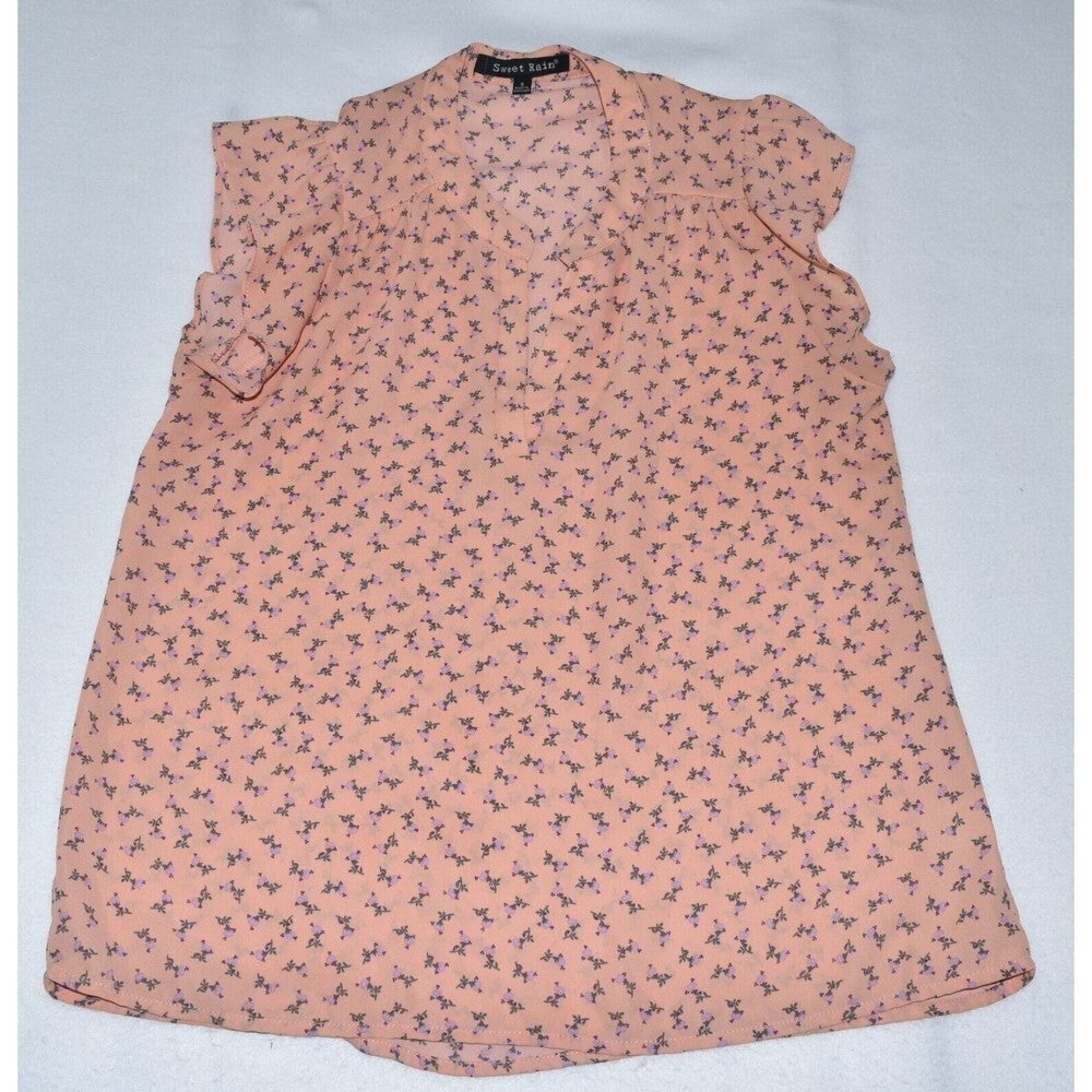 A sleeveless peach-colored blouse with a small all-over floral print, laid flat on a light gray background. The brand name 'Port & Company' is visible on the inner neck label.