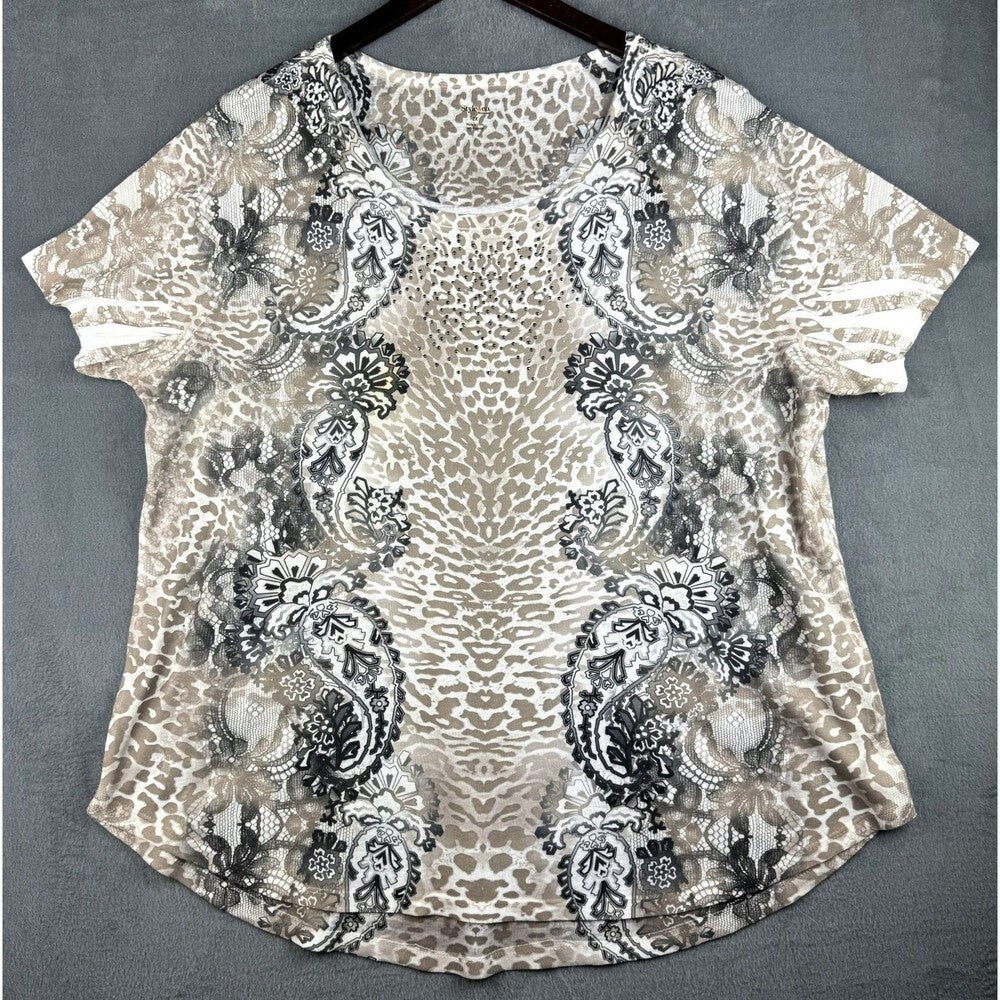 A short-sleeve women's blouse with a mixed animal and paisley print in beige, brown, black, and gray, hanging on a dark hanger against a textured gray background.