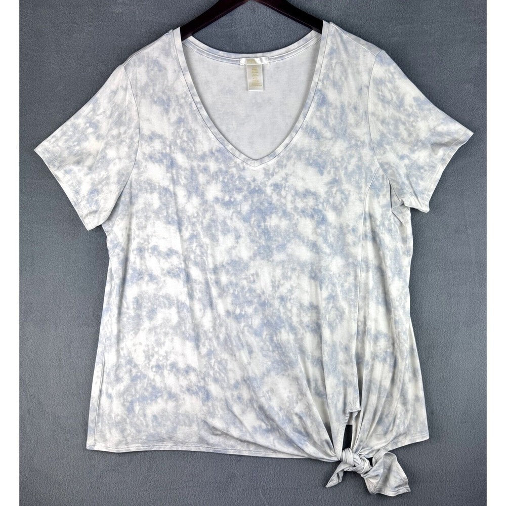 A women's short-sleeve V-neck tie-dye top in white and light blue, featuring a front knot detail at the hem, displayed on a hanger against a gray textured background.
