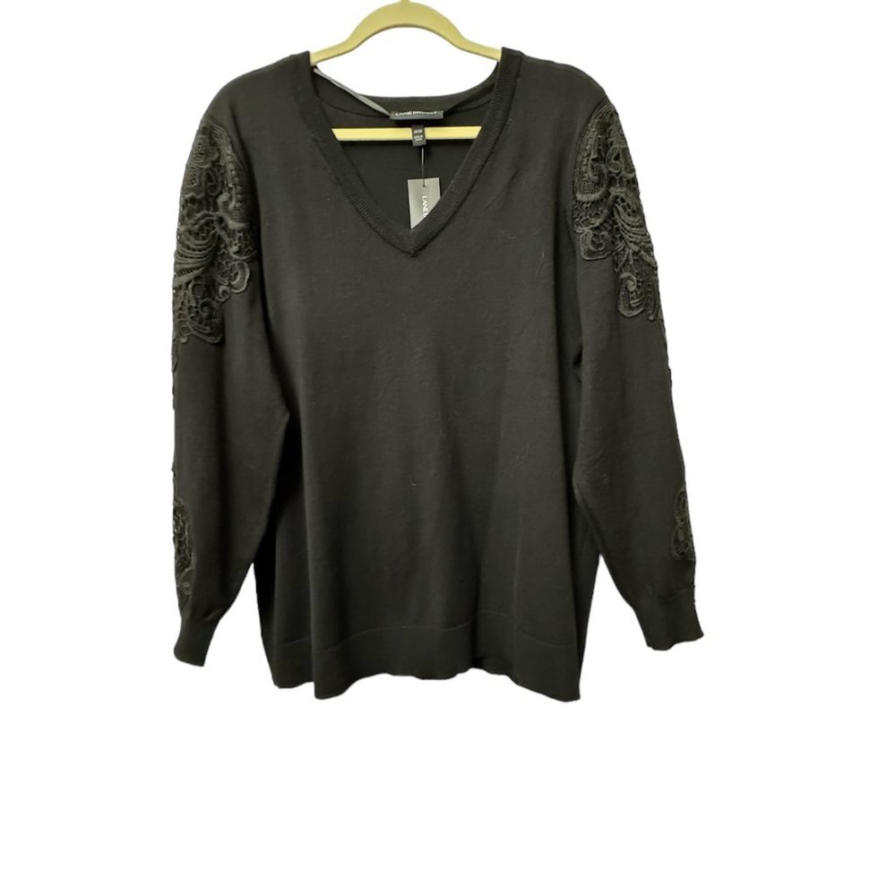 A dark olive green long-sleeve V-neck sweater with intricate dark lace applique detailing on the upper sleeves, hanging on a wooden hanger against a white background.