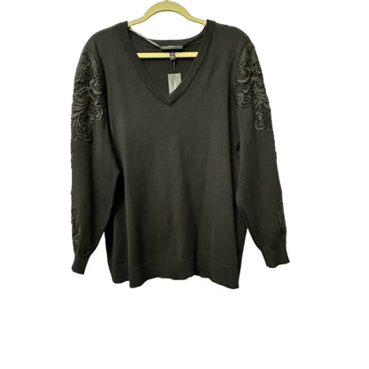 A dark olive green long-sleeve V-neck sweater with intricate dark lace applique detailing on the upper sleeves, hanging on a wooden hanger against a white background.
