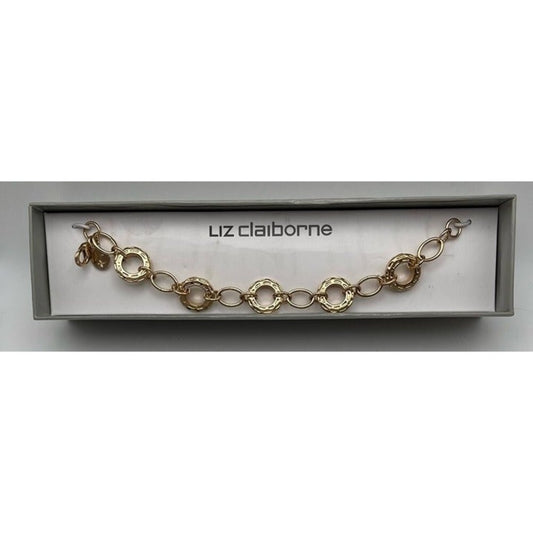 A gold-tone chain bracelet with textured circular links, presented inside a light gray box with the brand name 'luz claiborne' printed on the insert.