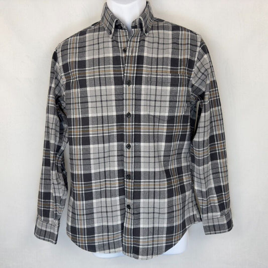 A long-sleeve button-down plaid shirt in black, gray, and white with thin tan stripes, displayed on a white mannequin torso against a light off-white background.