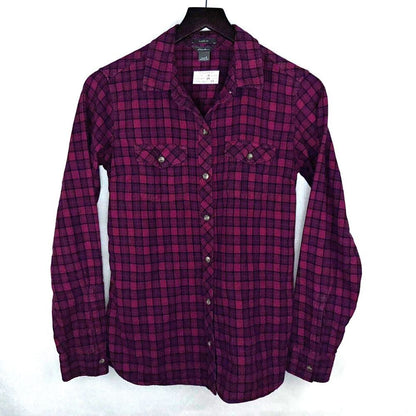 A long-sleeve button-up plaid shirt in dark magenta and black, hanging on a black hanger against a white background.