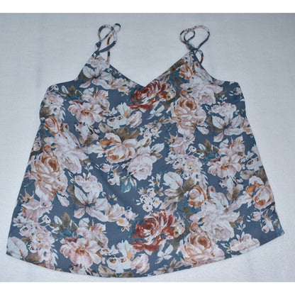 A sleeveless floral camisole top with thin shoulder straps, featuring a dense rose and floral print in dusty blue, beige, white, and rust orange tones, laid flat on a light gray background.