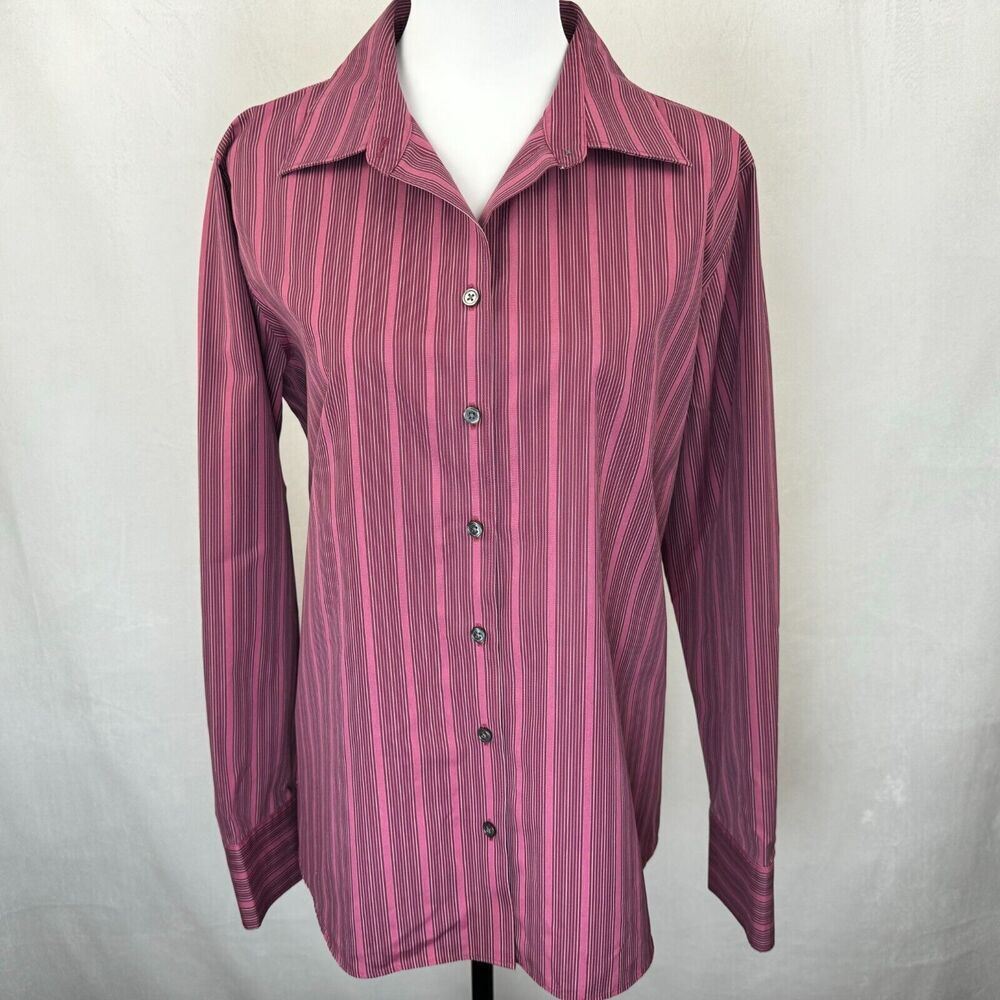 A long-sleeve button-up shirt with vertical pink and purple stripes, displayed on a white mannequin torso against a light gray fabric backdrop.