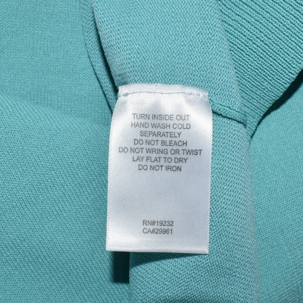 Clothing care tag view on Alfred Dunner knit green top with white background