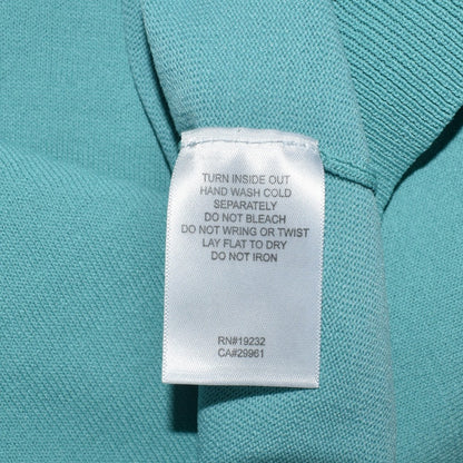 Clothing care tag view on Alfred Dunner knit green top with white background