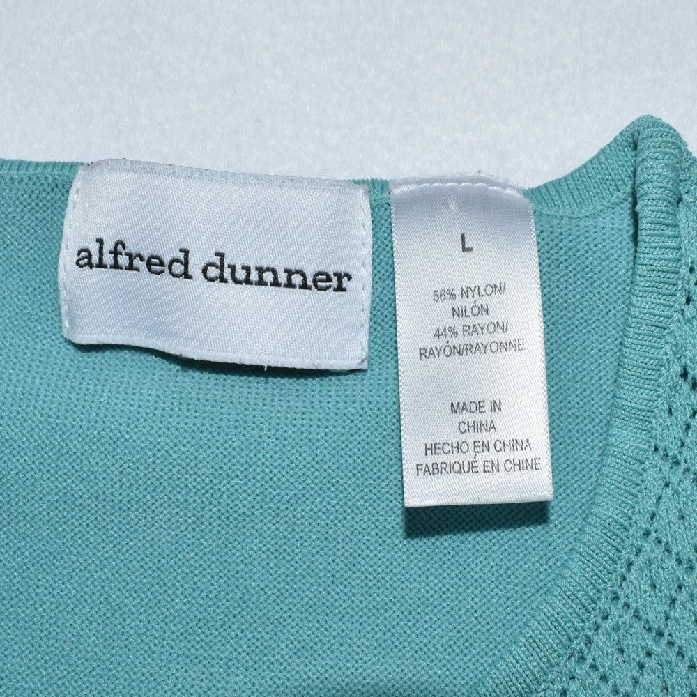Clothing tag view on Alfred Dunner knit top in green on a white background