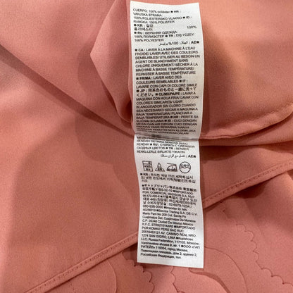 Close-up of a care label of a Banana Republic pink garment with text and symbols.
