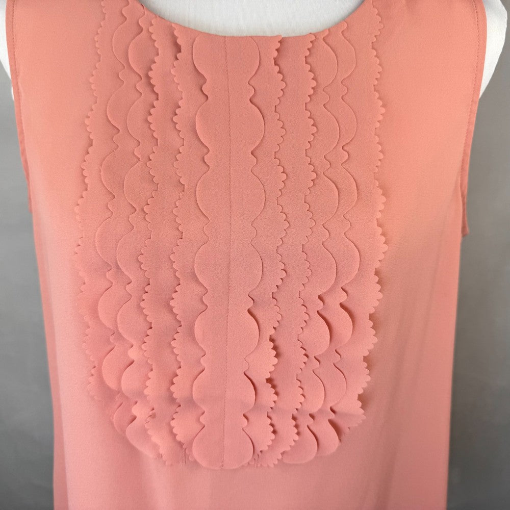 Close-up of a Banana Republic pink sleeveless top with scalloped detail pattern on a gray background