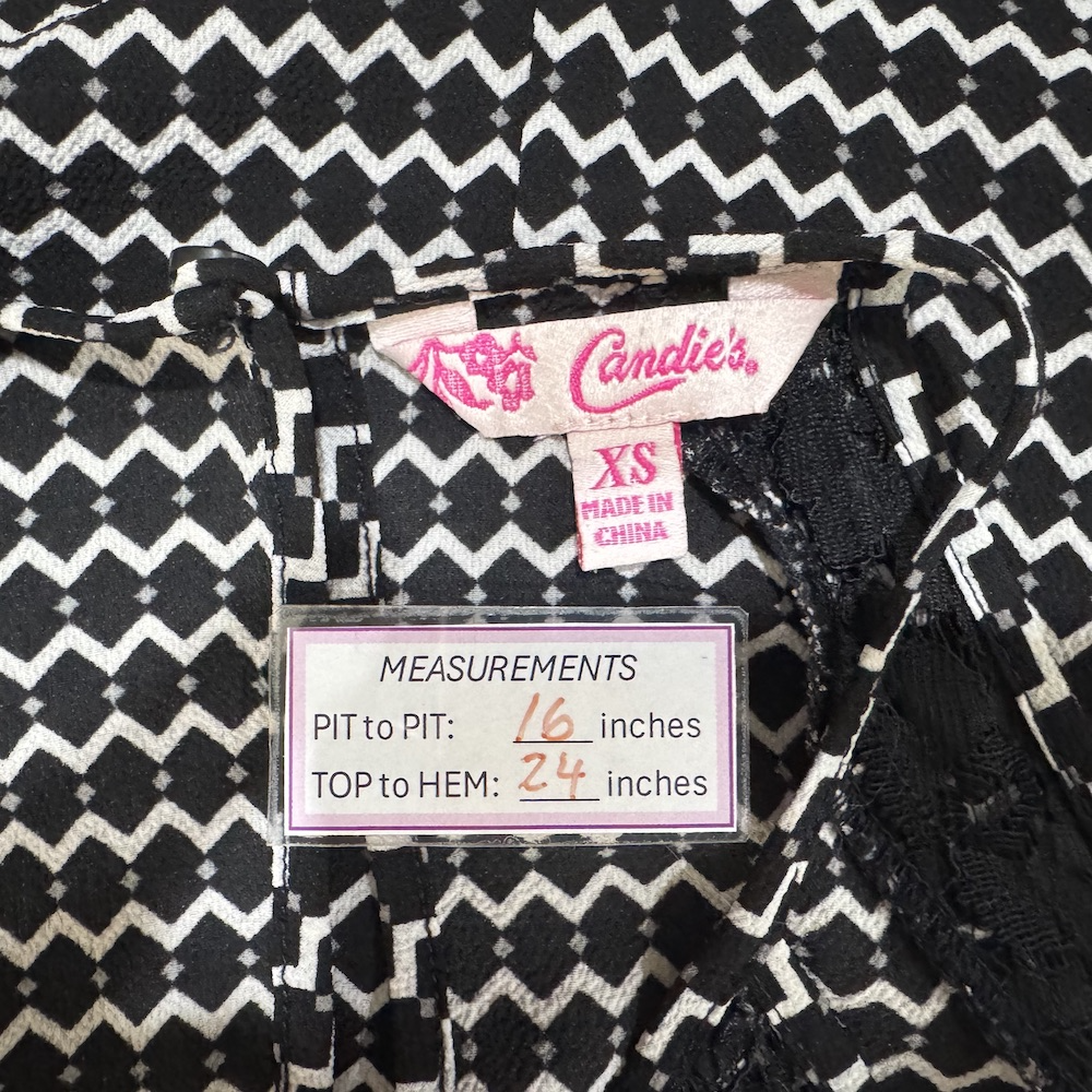 Clothing tag view on Candie's label with measurements on a black and white patterned fabric background