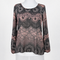 A long-sleeve lace top displayed on a white mannequin torso against a plain white background. The top features an intricate floral and paisley lace pattern in black and dusty rose pink.