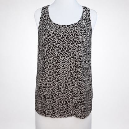 A sleeveless scoop-neck top with an all-over small black and white floral or ditsy print, displayed on a white mannequin torso against a light gray background.