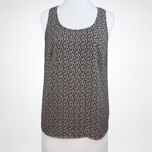 A sleeveless scoop-neck top with an all-over small black and white floral or ditsy print, displayed on a white mannequin torso against a light gray background.