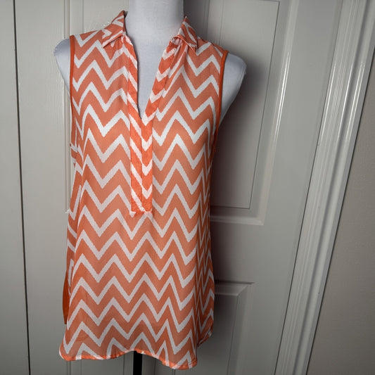 Front view on Femme by Tresics orange and white chevron patterned sleeveless top on a mannequin against a white background