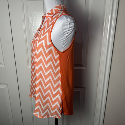 Side view on Femme by Tresics orange and white chevron patterned sleeveless top on a mannequin against a white door.
