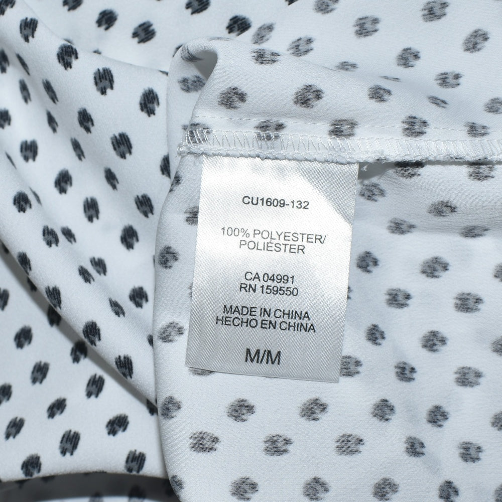 Clothing material tag view on Hilary Radley blouse on a piece of fabric with a subtle pattern