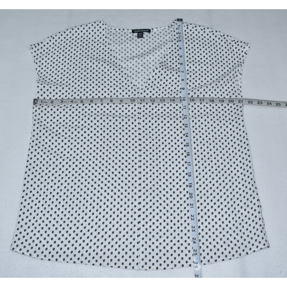 Measurements view on Hilary Radley white with black polka dot shirt on a gray background with a measuring tape.