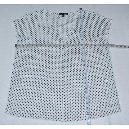 Measurements view on Hilary Radley white with black polka dot shirt on a gray background with a measuring tape.