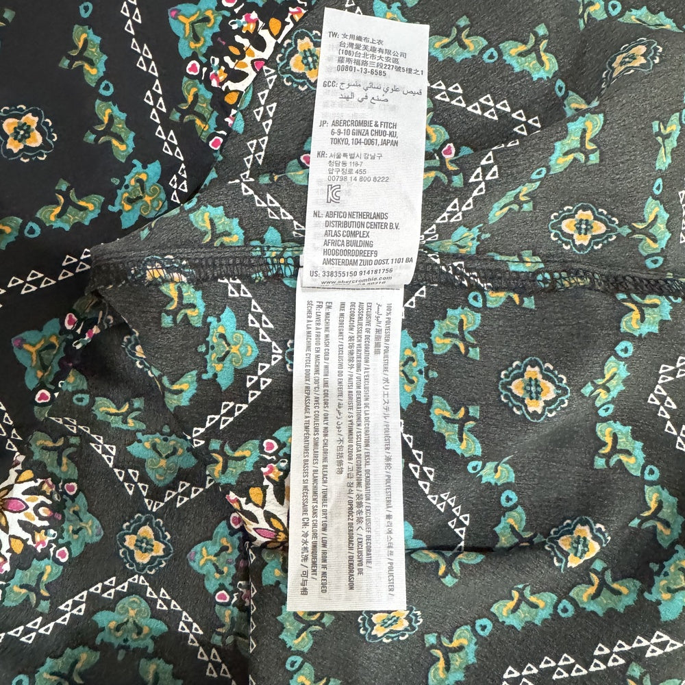 Clothing material tag view on Hollister Floral patterned top with a label in the center