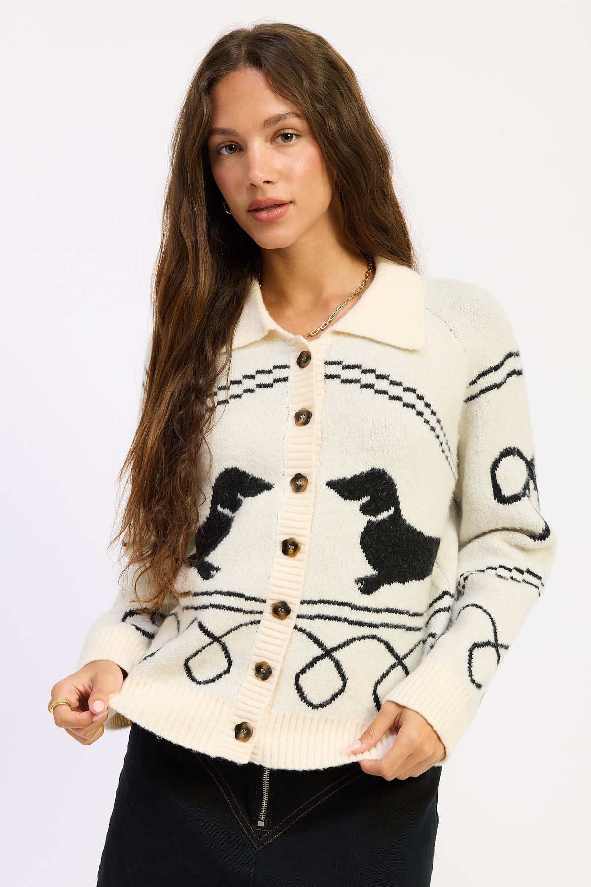 Model wearing Emory Park Robin Cardigan in ivory and black with dog motifs, collared neckline, long sleeves and button-front closure.